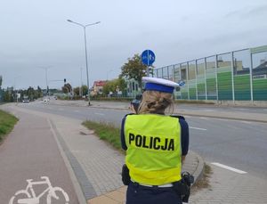 Zdjęcie przedstawiające policjantkę podczas wykonywania pomiaru prędkości