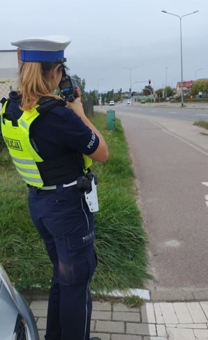 Zdjęcie przedstawiające policjantkę podczas wykonywania pomiaru prędkości