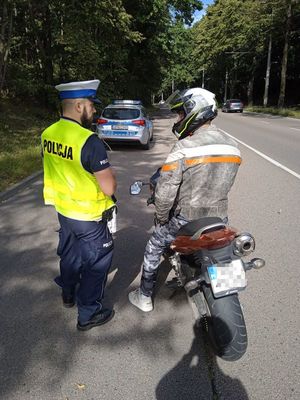 Zdjęcie przedstawiające policjanta podczas kontroli motocyklisty