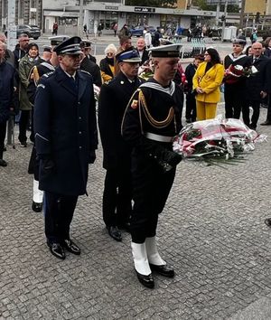 Zdjęcie przedstawiające obchody 84. rocznicy wysiedlenia gdynian. Na zdjęciu widać osoby cywilne, marynarzy, Komendanta Miejskiego Policji w Gdyni oraz Komendanta Miejskiego Państwowej Straży Pożarnej w Gdyni