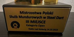 Zdjęcie przedstawiające tabliczkę, która umieszczona jest na pucharze. Na tabliczce jest informacja o zajęciu II miejsca.