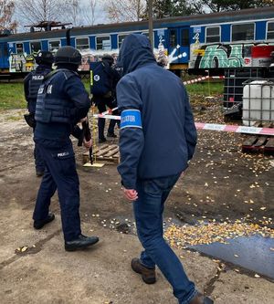 Zdjęcie przedstawiające policjantów idących w kierunku pociągu