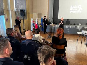 Zdjęcie przedstawiające  panią dyrektor szkoły, policjantów oraz innych uczestników podczas inauguracji kampanii Biała Wstążka