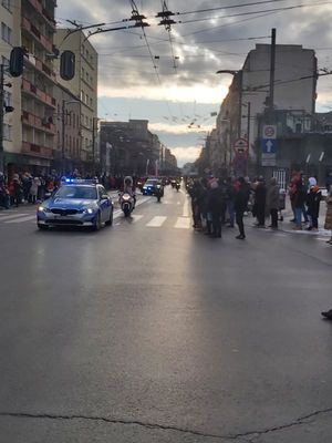 Zdjęcie przedstawiające jadący radiowóz, a za nim przejazd Mikołajów na motocyklach i kładach