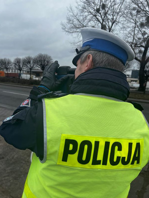 Zdjęcie przedstawiające policjanta podczas pomiaru prędkości