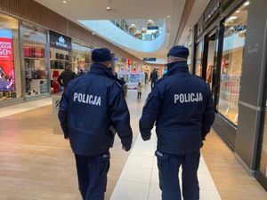 Zdjęcie przedstawiające dwóch policjantów idących w galerii handlowej