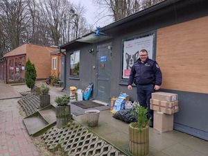 Zdjęcie przedstawiające policjanta z darami dla bezdomnych zwierząt