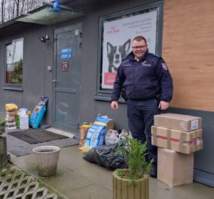 Zdjęcie przedstawiające policjanta z darami dla bezdomnych zwierząt