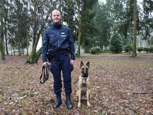 Zdjęcie przedstawiające policjanta z psem służbowym