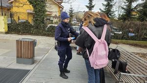 Zdjęcie przedstawiające policjantkę, która rozdaje młodzieży ulotki