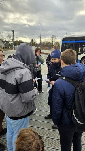 Zdjęcie przedstawiające policjantkę, która rozdaje młodzieży ulotki