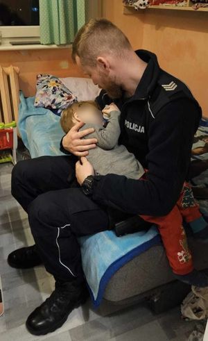Zdjęcie przedstawiające policjanta, który usypia 3-letniego chłopca