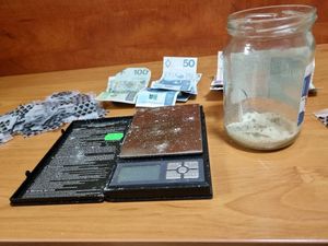 Zdjęcie przedstawiające woreczki, pieniądze, wagę i słoik z białą substancją