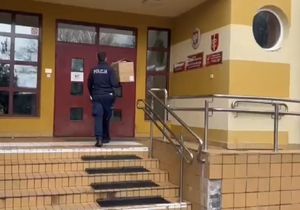 Zdjęcie przedstawiające policjanta, który wchodzi do szkoły