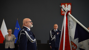 Zdjęcie przedstawiające insp. Dariusza Walichnowskiego stojącego przed sztandarem, podczas uroczystego pożegnania