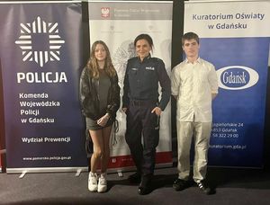 Zdjęcie przedstawiające policjantkę z Gdyni oraz uczennicę i ucznia SP nr 18 w Gdyni