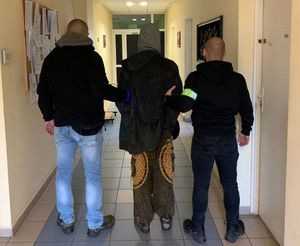 Zdjęcie przedstawiające policjantów, którzy prowadzą zatrzymanego mężczyznę