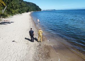 Zdjęcie przedstawiające wspólny patrol Policji i PSP na plaży.