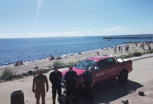 Zdjęcie przedstawiające wspólny patrol Policji i PSP na plaży.