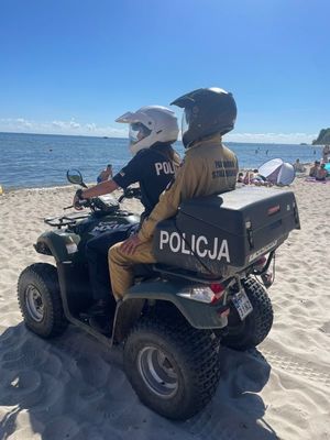 Zdjęcie przedstawiające wspólny patrol Policji i PSP na plaży.