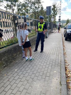 Zdjęcie przedstawiające policjantkę, która rozmawia z dwiema uczennicami.