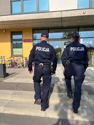 Zdjęcie przedstawiające policjantkę i policjanta, nadzorujących rejon szkół.