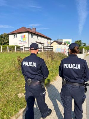 Zdjęcie przedstawiające policjantkę i policjanta, nadzorujących rejon szkół.