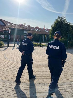 Zdjęcie przedstawiające policjantkę i policjanta, nadzorujących rejon szkół.