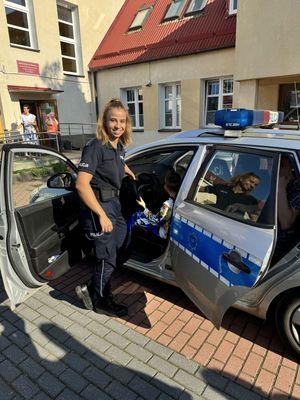 Zdjęcie przedstawiające policjantkę przy radiowozie