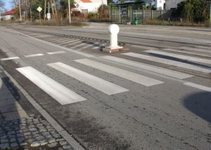 Zdjęcie przedstawiające na poboczu ulicy samochód osobowy, radiowóz policyjny, karetkę pogotowia, samochód dostawczy oraz trzy młode osoby.