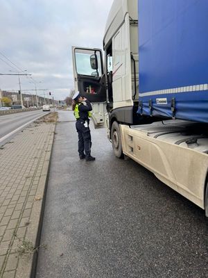 Zdjęcie przedstawiające policjantkę podczas kontroli samochodu ciężarowego.