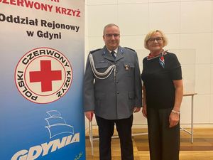 Zdjęcie przedstawiające policjanta i kobietę