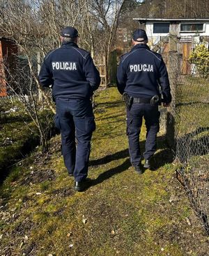 Zdjęcie przedstawiające policjantów podczas patrolowania ogródków działkowych.