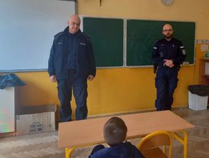 Zdjęcie przedstawiające dzielnicowych podczas prowadzenia lekcji z uczniami.