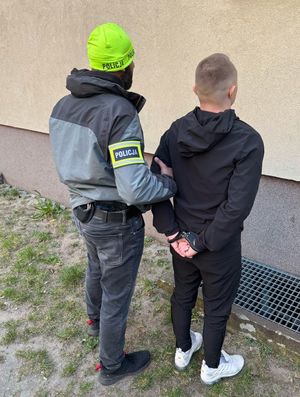 Zdjęcie przedstawiające policjanta z zatrzymanym mężczyzną.