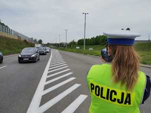 Zdjęcie przedstawiające policjantkę podczas wykonywania pomiaru prędkości.