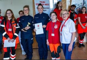 Zdjęcie przedstawiające policjantki, ratowników oraz innych uczestników zawodów młodzieżowych z pierwszej pomocy medycznej.