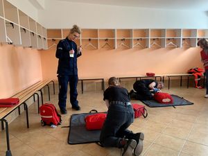 Zdjęcie przedstawiające policjantkę podczas sędziowania w zawodach młodzieżowych z pierwszej pomocy medycznej.