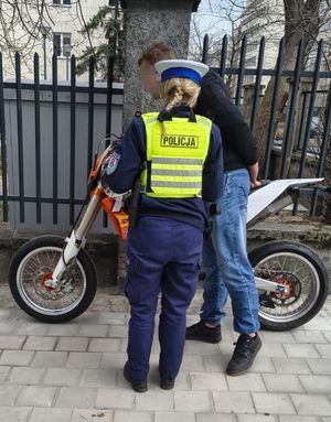 Zdjęcie przedstawiające policjantkę podczas kontroli kierowcy jednośladu.