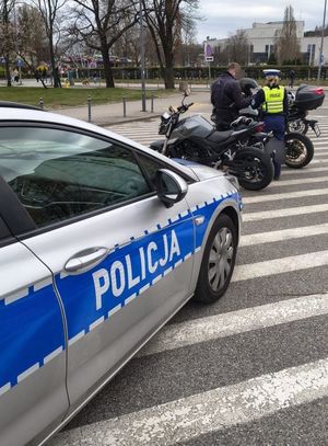 Zdjęcie przedstawiające policjantkę podczas kontroli motocyklisty.
