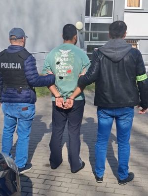 Zdjęcie przedstawiające policjantów z zatrzymanym mężczyzną.