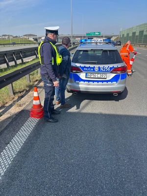 Zdjęcie przedstawiające policjanta z zatrzymanym mężczyzną.