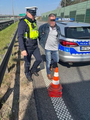 Zdjęcie przedstawiające policjanta z zatrzymanym mężczyzną.