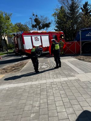 Zdjęcie przedstawiające policjantów ruchu drogowego podczas wykonywania czynności na miejsca wypadku.