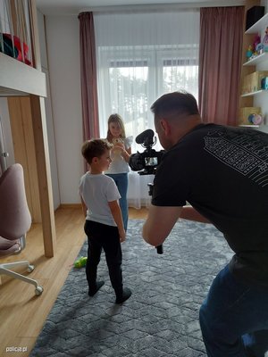 Zdjęcie poglądowe, przedstawiające fotografa, który robi zdjęcie dwójce dzieci.