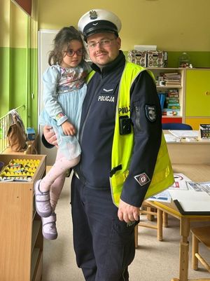 Zdjęcie przedstawiające policjanta z córką na rękach