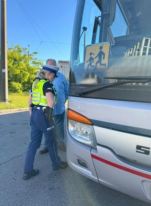 Zdjęcie przedstawiające policjantkę idącą do autokaru.