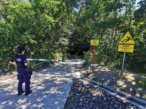 Zdjęcie przedstawiające policjantkę przy wjeździe na plażę oksywską, przeznaczonym dla służb.