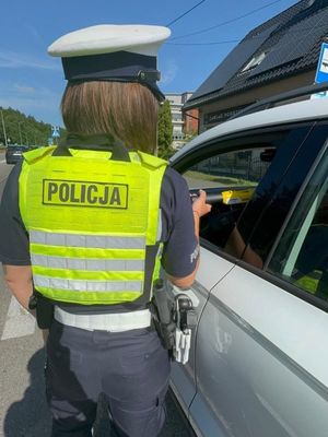 Zdjęcie przedstawiające policjantkę podczas kontroli drogowej.