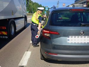 Zdjęcie przedstawiające policjantkę podczas kontroli drogowej.
